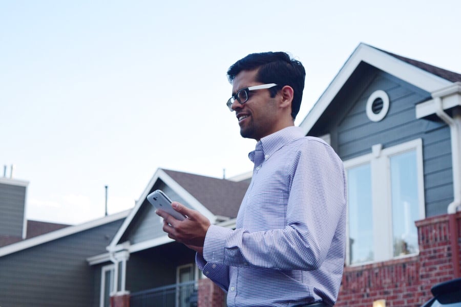 Man-on-Phone-in-front-of-house