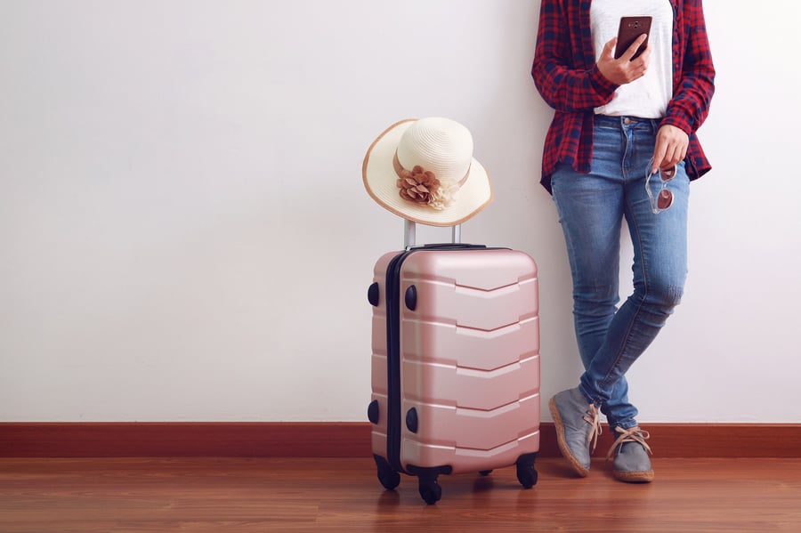 asian-woman-traveler-looking-at-smart-phone-carry-pink-luggage-with-hat_t20_W7odEL