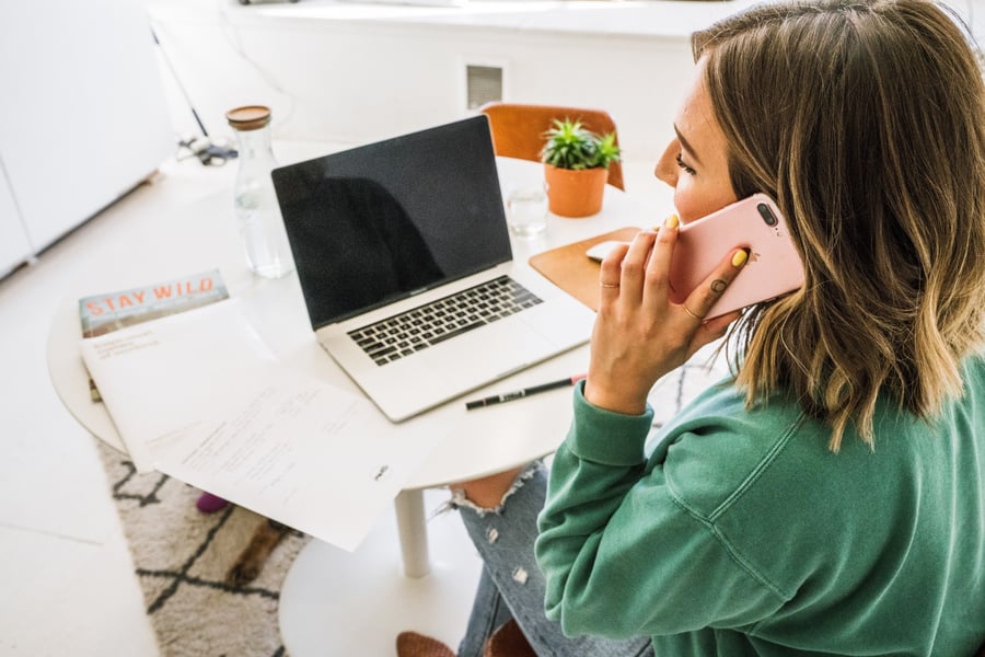 business-woman-at-her-desk-in-a-bright-minimalist-office-taking-a-phone-call_t20_QzB6gb